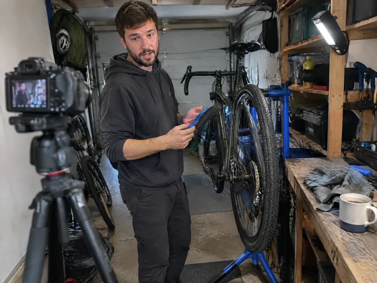 A creator filming a bike repair tutorial in his garage